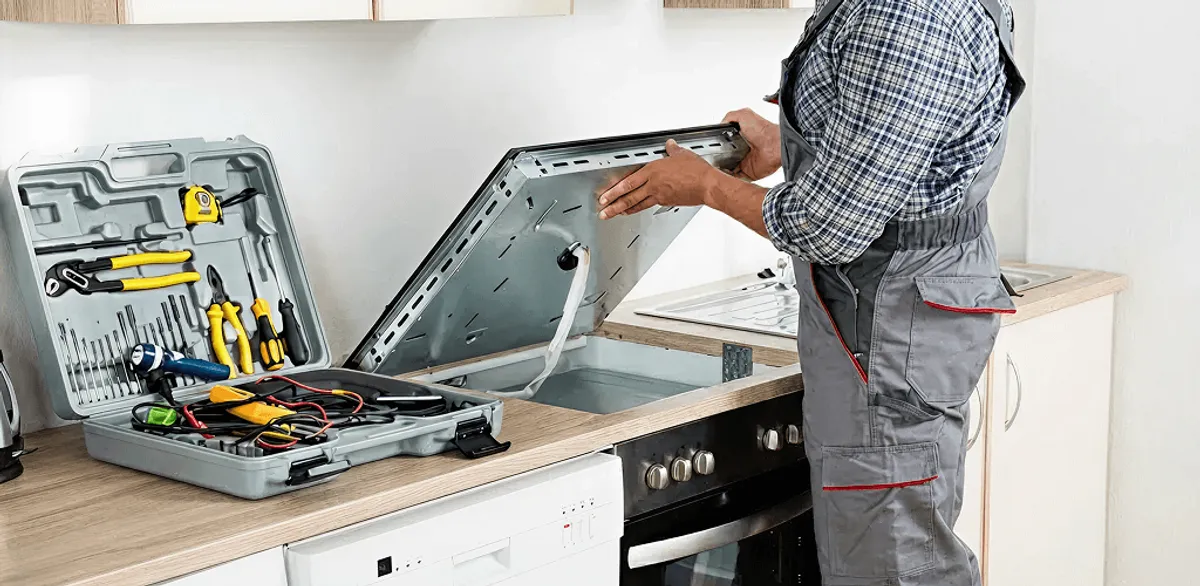 Handyman repairing a cooktop and checking wiring connections in Mobile, AL
