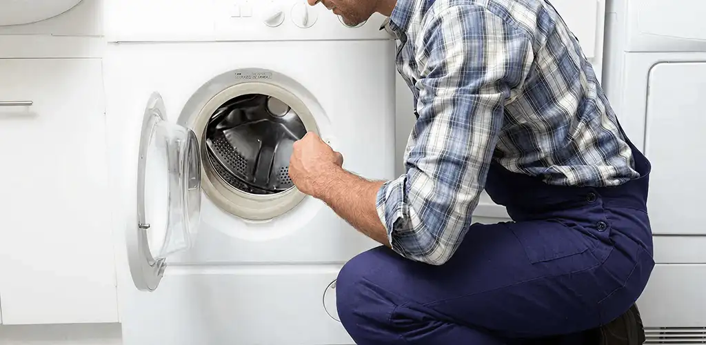 Handyman inspecting a dryer drum and internal parts for repair in Mobile, AL