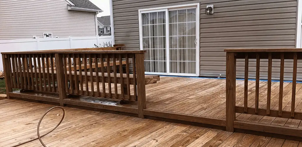 Deck sealing service protecting a backyard wood deck and railings in Mobile, AL