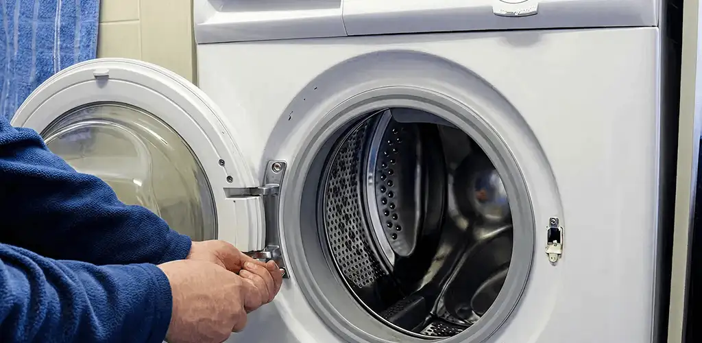 Washing machine repair handyman checking a front-load washer door and latch in Mobile, AL