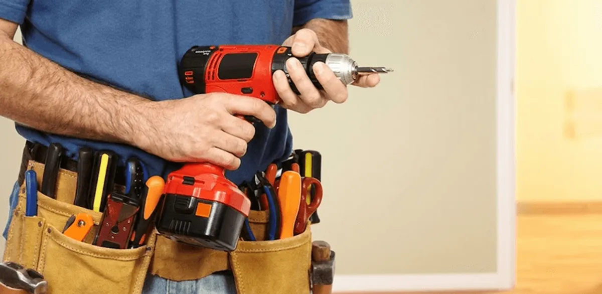Handyman holding a power drill for home repairs and installations in Mobile, AL