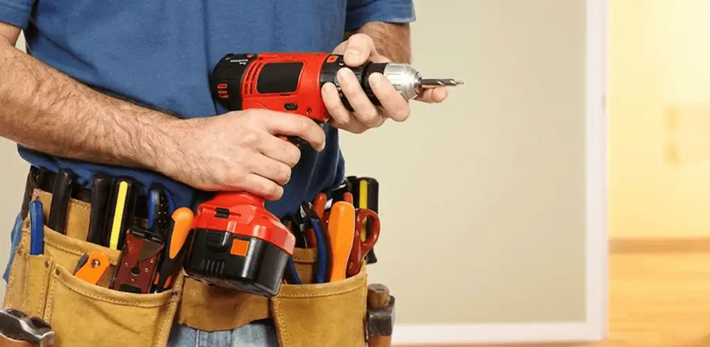 Handyman holding a power drill for home repairs and installations in Mobile, AL
