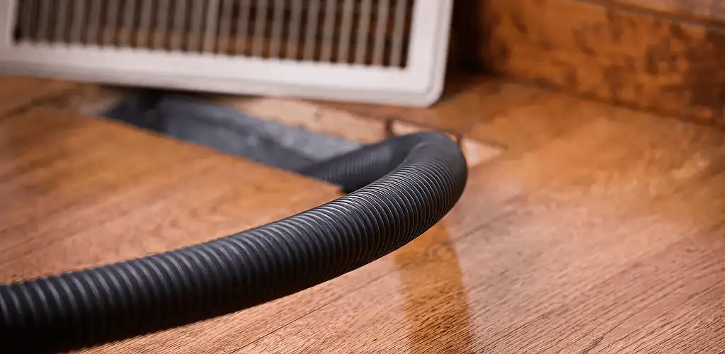 Air duct cleaning hose inserted into a floor vent for ductwork cleaning in Mobile, AL